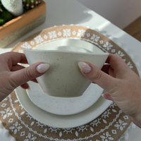 Vanaway Speckled Coconut white rPET bowl held in both hands to demonstrate size, lightweight construction and the subtle grey speckled finish. asymmetrical dinnerware