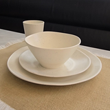 Vanaway Speckled Coconut white rPET dinnerware place setting with dinner plate, side plate, bowl and cup styled on a natural linen table runner, highlighting the subtle speckled finish and modern lightweight design. asymmetrical dinnerware