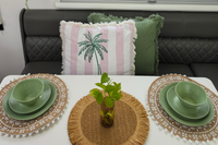 Speckled Matcha green recycled plastic camping dinnerware set on a caravan dining table with woven placemats and green décor asymmetrical dinnerware