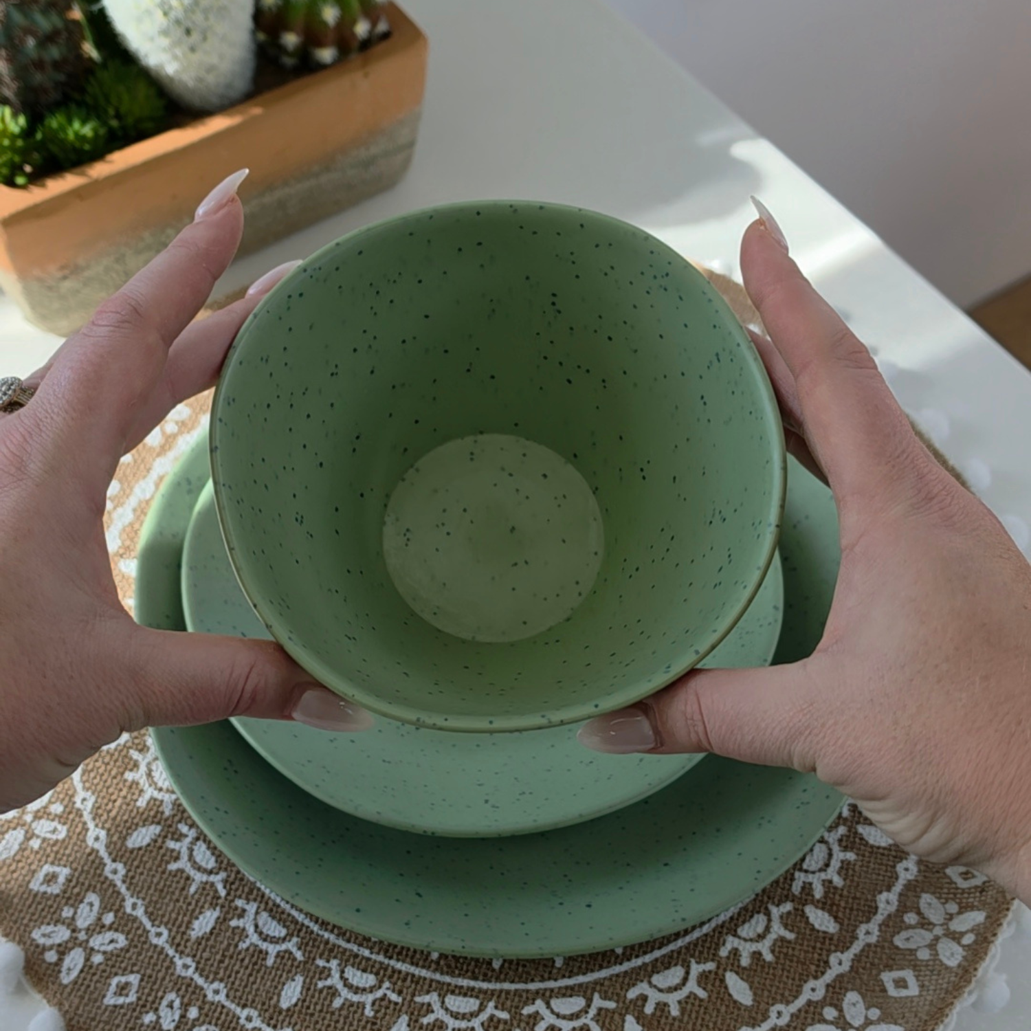 Top-down view of the Vanaway Speckled Matcha rPET bowl held in both hands, showcasing its generous 700 ml capacity, speckled finish and matte sage green colour. asymmetrical dinnerware