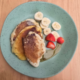 Vanaway Speckled Matcha rPET dinner plate served with fluffy pancakes, sliced banana, fresh strawberries and maple syrup, showcasing the plate's generous size and speckled finish. asymmetrical dinnerware
