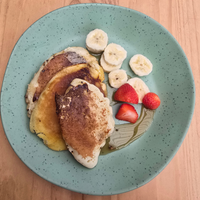 Vanaway Speckled Matcha rPET dinner plate served with fluffy pancakes, sliced banana, fresh strawberries and maple syrup, showcasing the plate's generous size and speckled finish. asymmetrical dinnerware