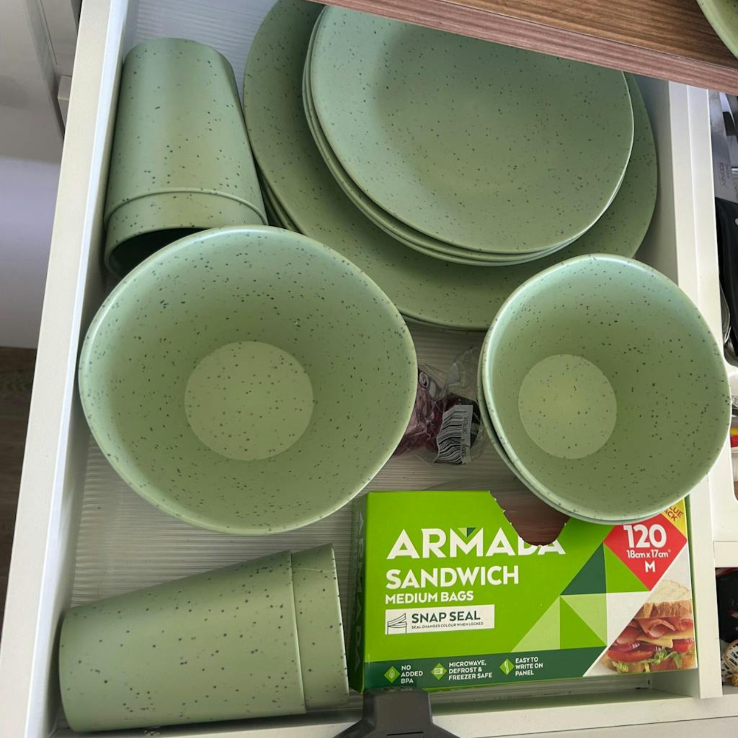 Vanaway Speckled Matcha rPET caravan dinnerware neatly organised inside a kitchen drawer, showing plates, bowls and tumblers stored compactly to maximise cupboard space while travelling asymmetrical dinnerware