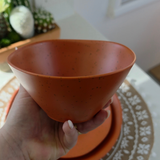 Vanaway Speckled Spice rPET caravan bowl held in hand, showcasing its generous depth, lightweight design and warm terracotta speckled finish. asymmetrical dinnerware