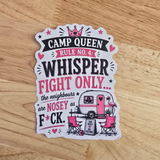 A die-cut sticker with a humorous camp queen slogan, displayed on a light wood grain surface. The sticker features a white background with pink and black text reading 'CAMP QUEEN RULE NO 4