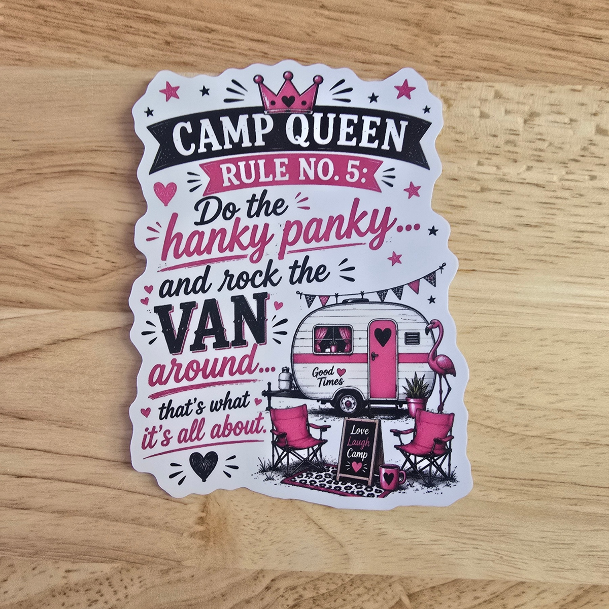 A die-cut sticker with a whimsical 'Camp Queen' design, featuring pink flamingos, a retro camper van, and text reading 'CAMP QUEEN RULE NO. 5: Do the hanky panky.