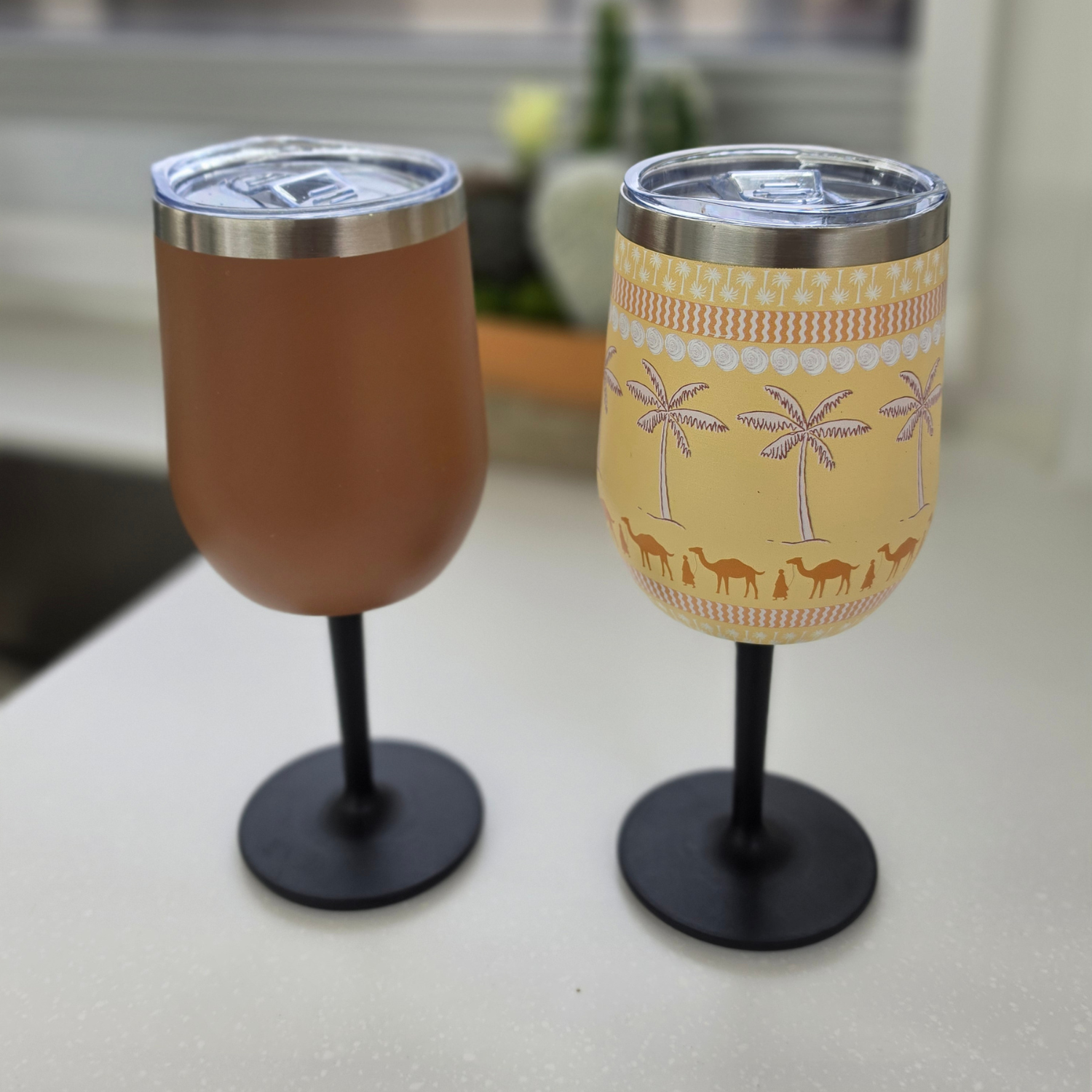 Vanaway insulated stainless steel wine tumblers with removable screw-on stems in Retro Brown and Golden Palms, displayed side by side to showcase the plain and printed designs.
