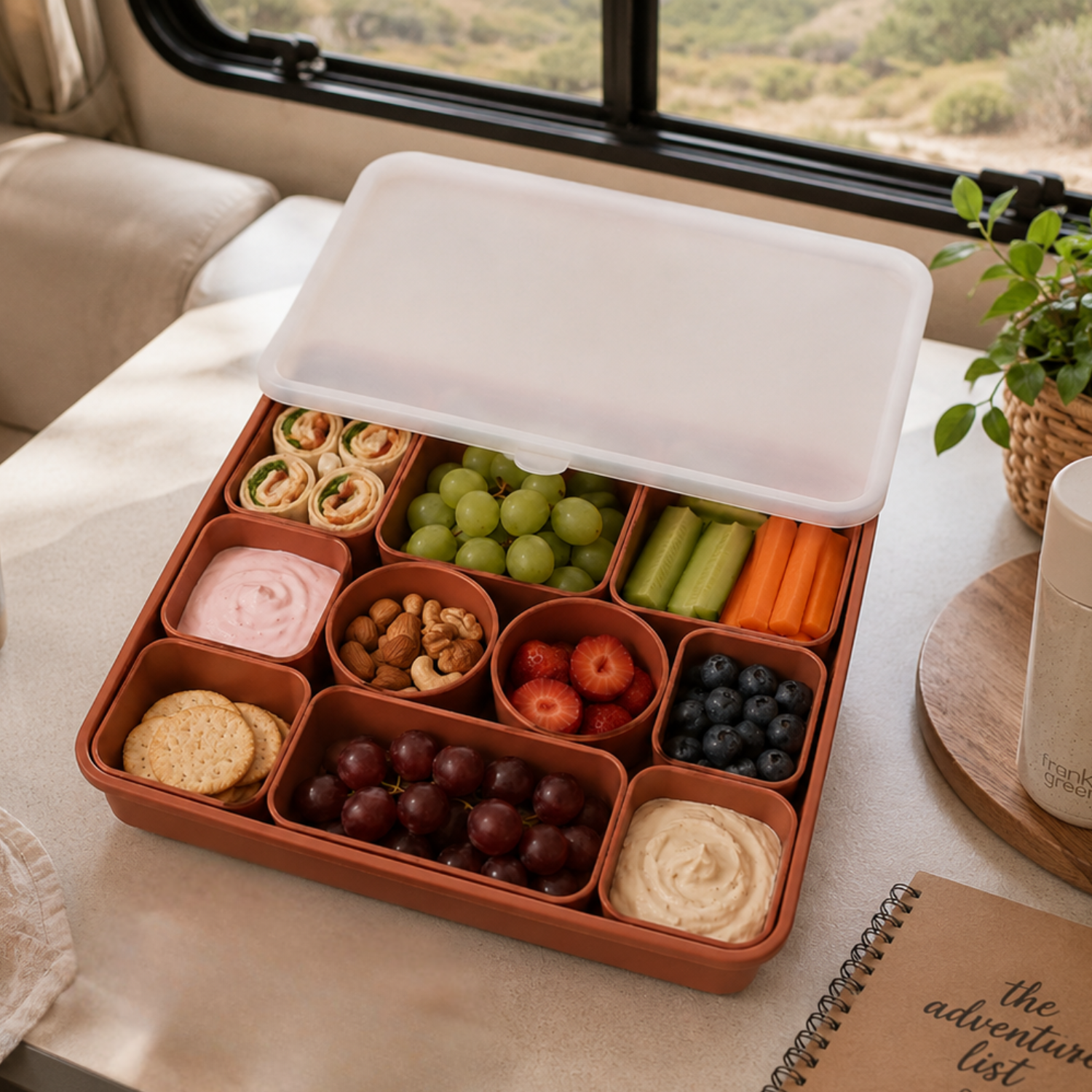 Vanaway Family Road Snack Box filled with healthy snacks on a caravan table with the translucent lid open
