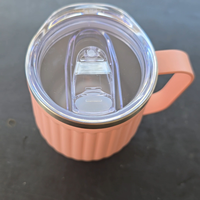camping Pink tumbler mug with handle with a clear lid on a dark surface