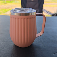 Pink mug with handle on a dark surface, blurred outdoor  camping background