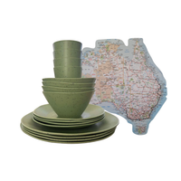 A set of speckled matcha green green caravan dinnerware, including bowls, plates, and a stack of cups, displayed alongside a cut-out map of Australia sticker on a plain white background.
