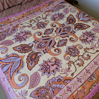 Close up of the Vanaway Dahlia woven travel throw rug showcasing its pink, lilac and terracotta paisley pattern with decorative fringe and premium woven texture.
