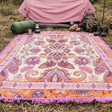 Vanaway Dahlia woven travel throw rug featuring a cream, lilac, lavender and terracotta boho paisley design, styled outside a tent with camping gear for comfortable outdoor adventures.