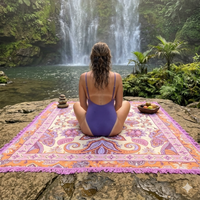 Vanaway Dahlia woven travel throw rug featuring a cream, lilac, lavender and terracotta boho paisley design, styled beside a tropical waterfall for camping, caravanning and outdoor adventures.