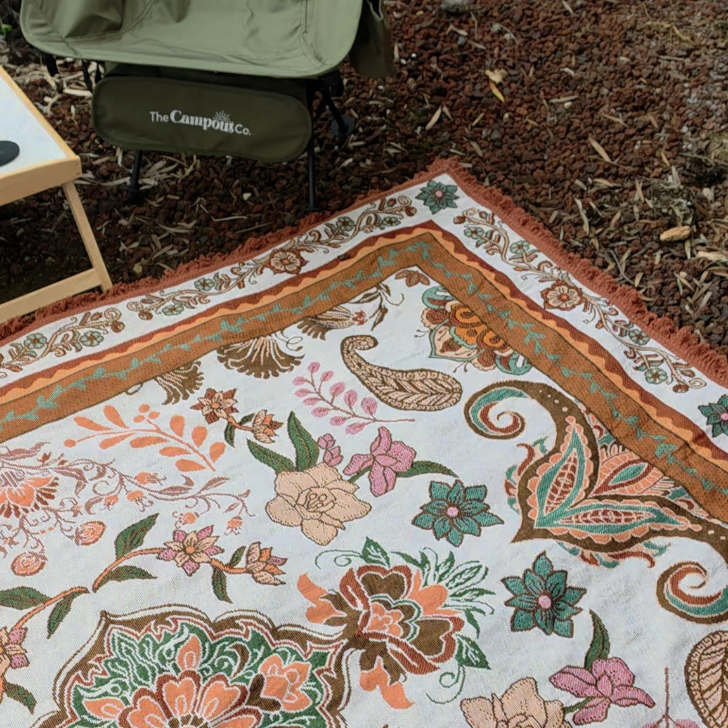 Close up of the Vanaway Sahara woven travel throw rug showcasing its cream, terracotta, sage green and blush boho botanical pattern with intricate woven detailing and decorative fringe.