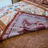 Vanaway Sahara woven travel throw rug folded to showcase its reversible design, featuring a cream, terracotta, sage green and blush boho botanical pattern with premium woven construction.