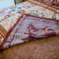 Vanaway Sahara woven travel throw rug folded to showcase its reversible design, featuring a cream, terracotta, sage green and blush boho botanical pattern with premium woven construction.