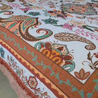 Close up of the Vanaway Sahara woven travel throw rug showcasing its cream, terracotta, sage green and blush boho botanical pattern with premium woven texture and fringed edge.