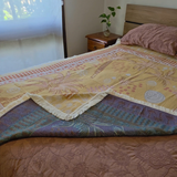 Vanaway Solana woven travel throw rug folded back to showcase its reversible design, premium woven cotton texture and decorative fringe, styled across a caravan bed.