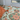 Vanaway Willow woven travel throw rug featuring soft blue, sage green, cream and terracotta botanical patterns, styled as a decorative bed throw inside a modern caravan.