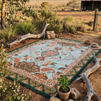 Vanaway Willow woven travel throw rug featuring soft blue, sage green, cream and terracotta botanical patterns, styled for an outdoor picnic in the Australian outback.